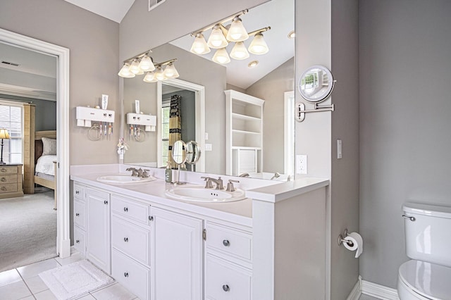 7340 Royal Ridge Dr SE, Caledonia, MI 49316 - ensuite bathroom with lofted ceiling, double vanity, toilet, and tile patterned floors
