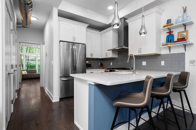 211 W Kingsley St, Ann Arbor, MI 48103 - kitchen with freestanding refrigerator, a peninsula, baseboards, wall chimney range hood, and light stone countertops