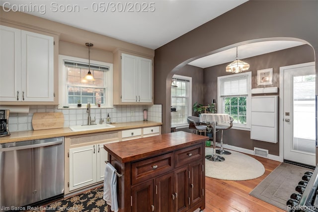 441 Mckinley Ave, Grosse Pointe Farms, MI 48236 - kitchen with butcher block counters, dishwasher, a sink, arched walkways, and backsplash