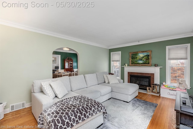 441 Mckinley Ave, Grosse Pointe Farms, MI 48236 - living room featuring ornamental molding, arched walkways, wood finished floors, a brick fireplace, and baseboards