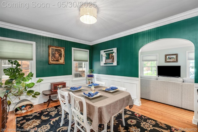 441 Mckinley Ave, Grosse Pointe Farms, MI 48236 - dining space featuring arched walkways, ornamental molding, wainscoting, and wood finished floors