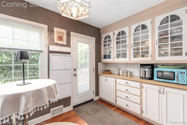 441 Mckinley Ave, Grosse Pointe Farms, MI 48236 - kitchen with stainless steel microwave, a chandelier, tasteful backsplash, light countertops, and white cabinets