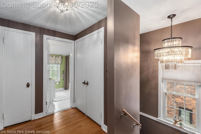 441 Mckinley Ave, Grosse Pointe Farms, MI 48236 - corridor with a chandelier, wood finished floors, and baseboards