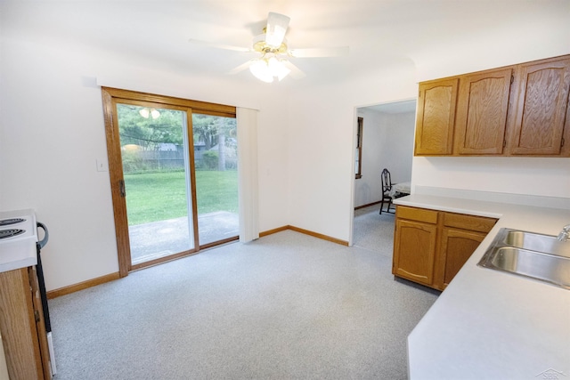 1202 Avalon Ave, Saginaw, MI 48638 - kitchen with a sink, light countertops, baseboards, light carpet, and ceiling fan