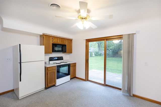 1202 Avalon Ave, Saginaw, MI 48638 - kitchen featuring range with electric cooktop, freestanding refrigerator, black microwave, baseboards, and light carpet