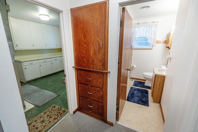 1202 Avalon Ave, Saginaw, MI 48638 - bathroom with toilet, vanity, and baseboards
