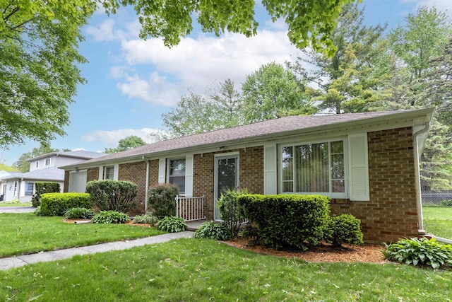 1202 Avalon Ave, Saginaw, MI 48638 - view of front facade with brick siding, a front yard, and a garage