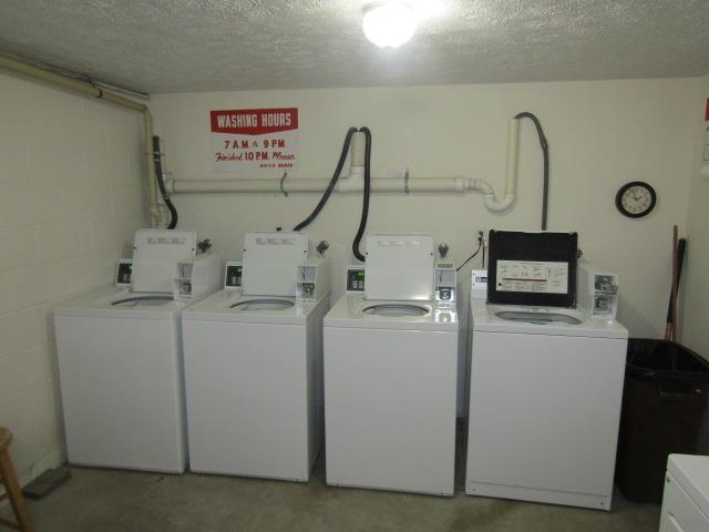 2024 Hamilton St, Okemos, MI 48864 - shared laundry featuring washer and clothes dryer, a textured ceiling, and concrete block wall
