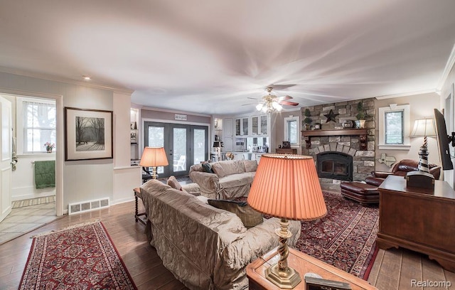 1786 Point St, Commerce Twp, MI 48382 - living area featuring crown molding, wood-type flooring, a stone fireplace, ceiling fan, and baseboards