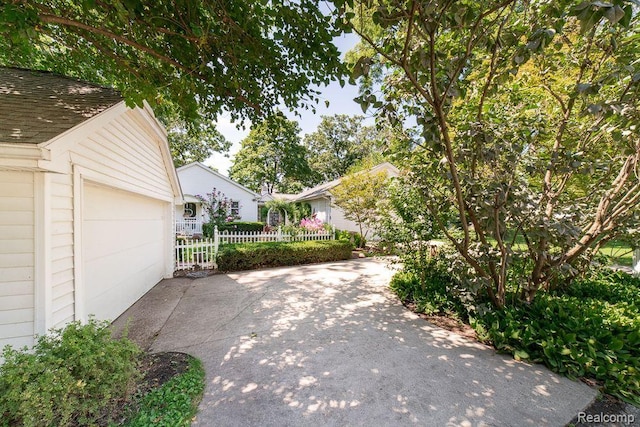 1786 Point St, Commerce Twp, MI 48382 - view of yard featuring a garage, an outbuilding, and driveway