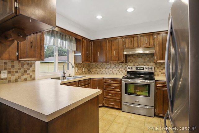 100 E 35th St, Holland, MI 49423 - kitchen featuring appliances with stainless steel finishes, under cabinet range hood, a sink, a peninsula, and light countertops