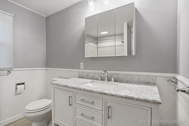 100 E 35th St, Holland, MI 49423 - bathroom with wainscoting, vanity, toilet, wood finished floors, and crown molding