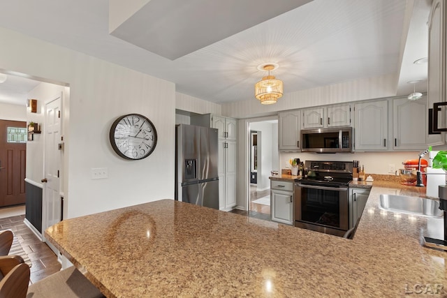 431 Meadowbrook Dr, Adrian, MI 49221 - kitchen featuring appliances with stainless steel finishes, a peninsula, gray cabinets, a sink, and light stone counters