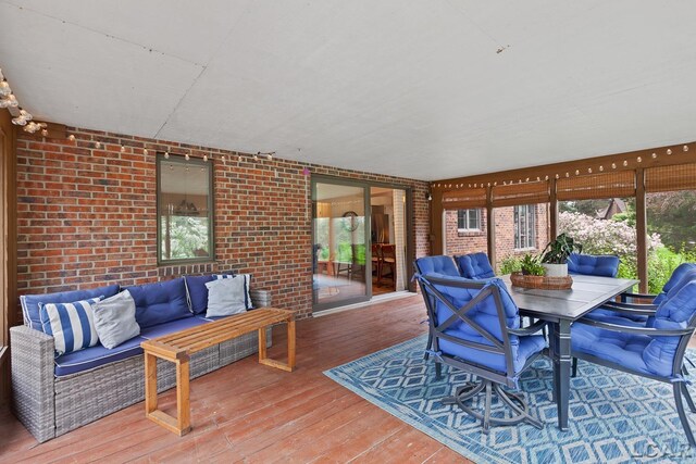 431 Meadowbrook Dr, Adrian, MI 49221 - sunroom / solarium with an outdoor living space, a deck, brick wall, hardwood / wood-style floors, and outdoor dining area