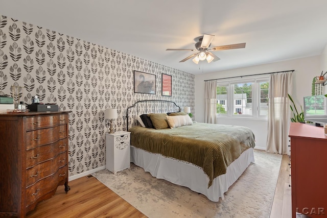 431 Meadowbrook Dr, Adrian, MI 49221 - bedroom featuring wallpapered walls, baseboards, light wood-style floors, an accent wall, and a ceiling fan