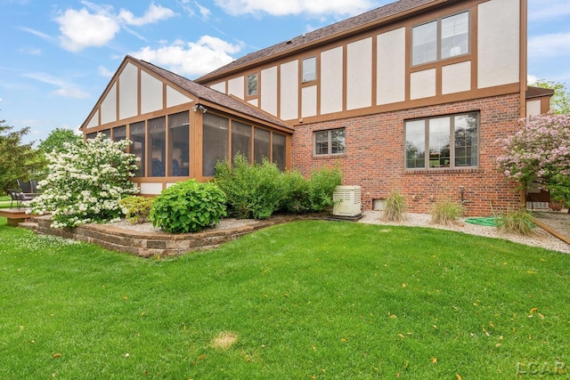 431 Meadowbrook Dr, Adrian, MI 49221 - back of house with brick siding, a sunroom, stucco siding, and a lawn