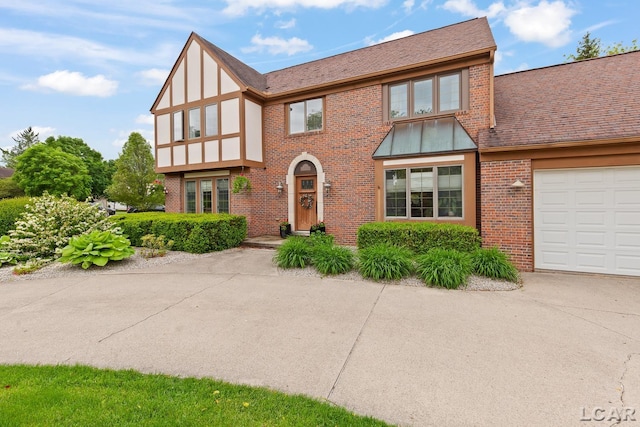 431 Meadowbrook Dr, Adrian, MI 49221 - english style home with brick siding, roof with shingles, an attached garage, and driveway