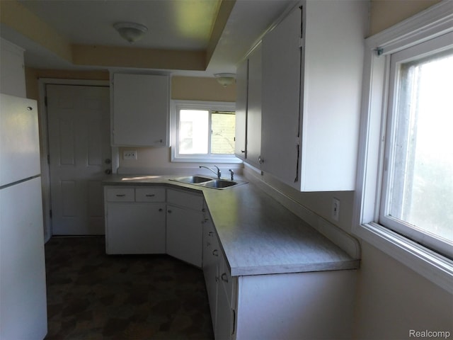 710 Washington St, Algonac, MI 48001 - kitchen with a sink, freestanding refrigerator, white cabinetry, light countertops, and dark floors