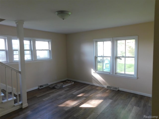 710 Washington St, Algonac, MI 48001 - spare room featuring baseboards, dark wood-type flooring, stairway, and ornate columns