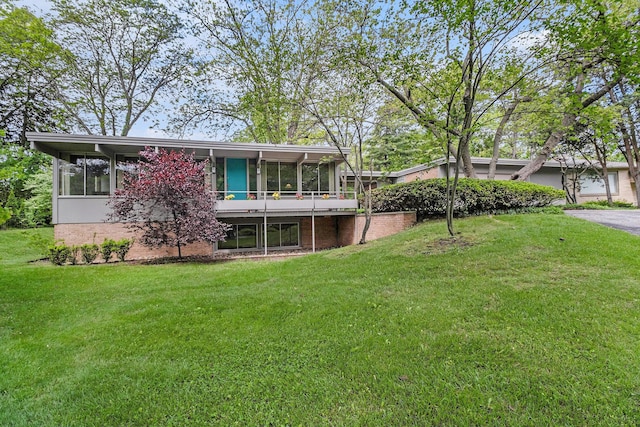 19 Heatheridge St, Ann Arbor, MI 48104 - back of property with a sunroom, a yard, and brick siding
