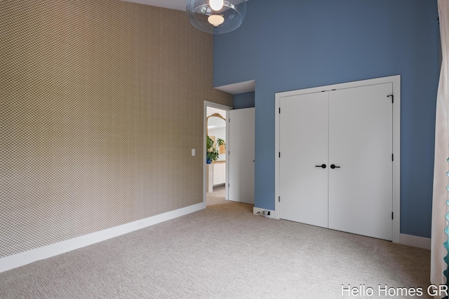 421 Manhattan Rd SE, Grand Rapids, MI 49506 - unfurnished bedroom featuring a towering ceiling, carpet flooring, and a closet