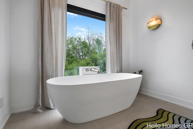 421 Manhattan Rd SE, Grand Rapids, MI 49506 - bathroom featuring baseboards and a freestanding tub