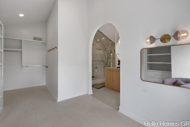421 Manhattan Rd SE, Grand Rapids, MI 49506 - hallway with lofted ceiling, arched walkways, recessed lighting, baseboards, and light tile patterned floors
