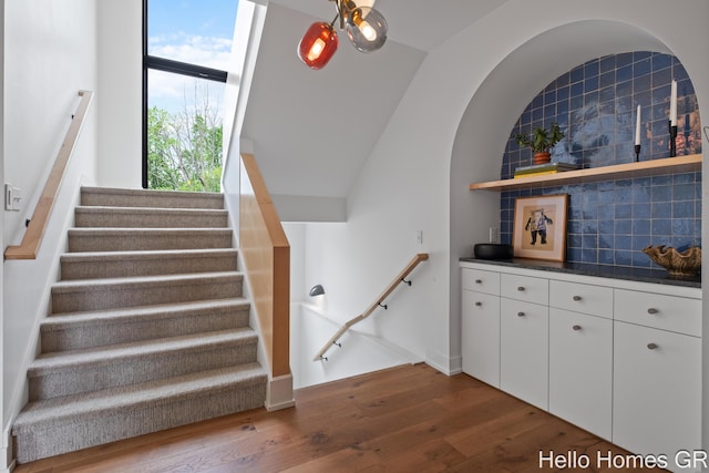 421 Manhattan Rd SE, Grand Rapids, MI 49506 - staircase featuring wood finished floors, a dry bar, baseboards, and lofted ceiling