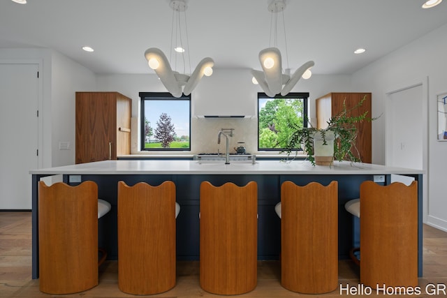 421 Manhattan Rd SE, Grand Rapids, MI 49506 - kitchen with a sink, recessed lighting, backsplash, light countertops, and a large island with sink