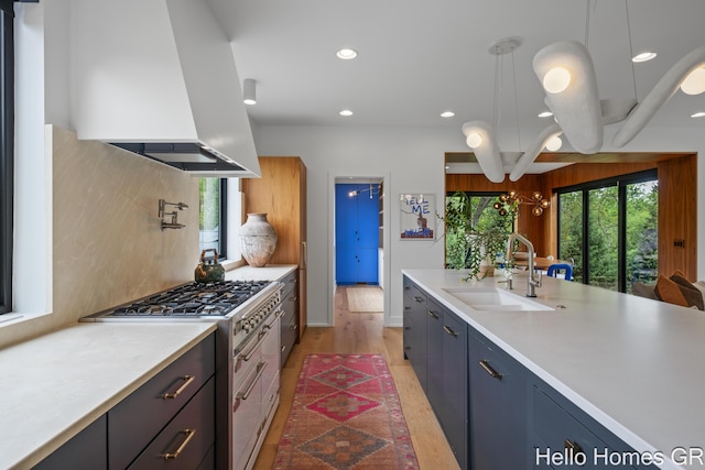 421 Manhattan Rd SE, Grand Rapids, MI 49506 - kitchen featuring island exhaust hood, a sink, light countertops, decorative backsplash, and recessed lighting