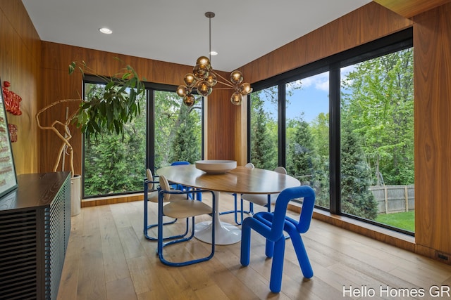 421 Manhattan Rd SE, Grand Rapids, MI 49506 - dining room with a chandelier, light wood-style flooring, and wooden walls