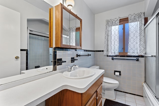 9085 Brentwood St, Livonia, MI 48150 - full bath with tile patterned floors, toilet, vanity, tile walls, and shower / bath combination with glass door