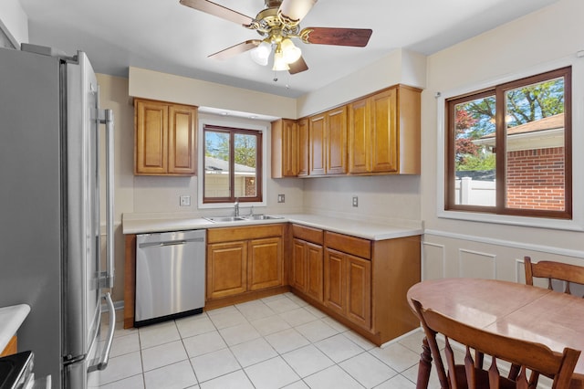 9085 Brentwood St, Livonia, MI 48150 - kitchen featuring stainless steel appliances, a sink, light countertops, light tile patterned flooring, and wainscoting