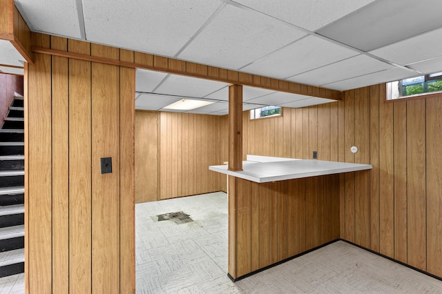 9085 Brentwood St, Livonia, MI 48150 - bar area with a drop ceiling, stairway, light flooring, and wood walls
