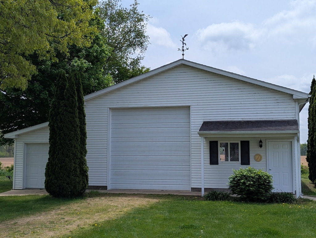 10639 Hanover Rd, Hanover, MI 49241 - view of side of property with a detached garage, a lawn, and an outbuilding