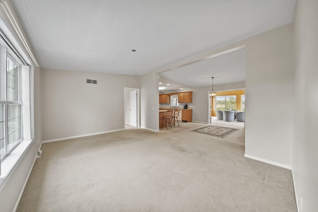 10639 Hanover Rd, Hanover, MI 49241 - unfurnished living room featuring baseboards, light carpet, and a chandelier