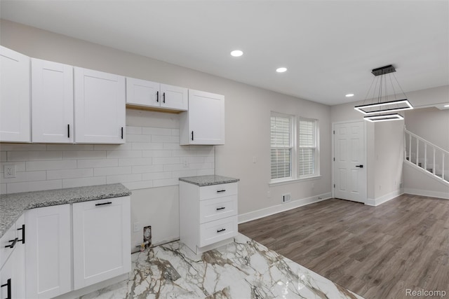 6080 Beniteau St, Detroit, MI 48213 - kitchen featuring light stone counters, white cabinets, decorative backsplash, recessed lighting, and light wood-style flooring