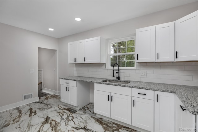 6080 Beniteau St, Detroit, MI 48213 - kitchen with a sink, light marble finish flooring, backsplash, white cabinets, and light stone countertops