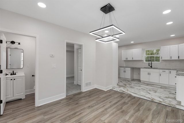 6080 Beniteau St, Detroit, MI 48213 - kitchen featuring a sink, white cabinetry, light wood-style flooring, recessed lighting, and a chandelier