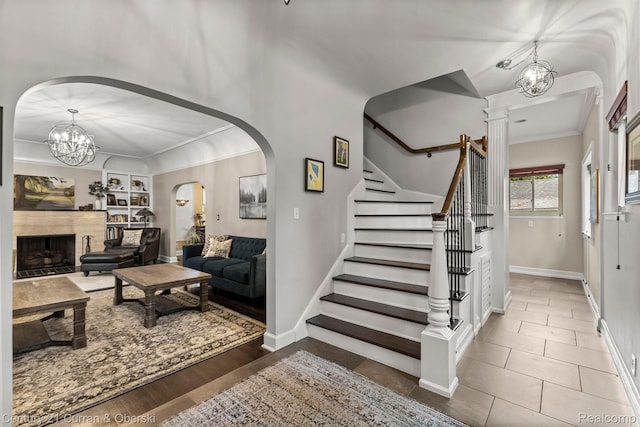 21975 Wildwood St, Dearborn, MI 48128 - tiled foyer featuring crown molding, stairs, baseboards, arched walkways, and a fireplace