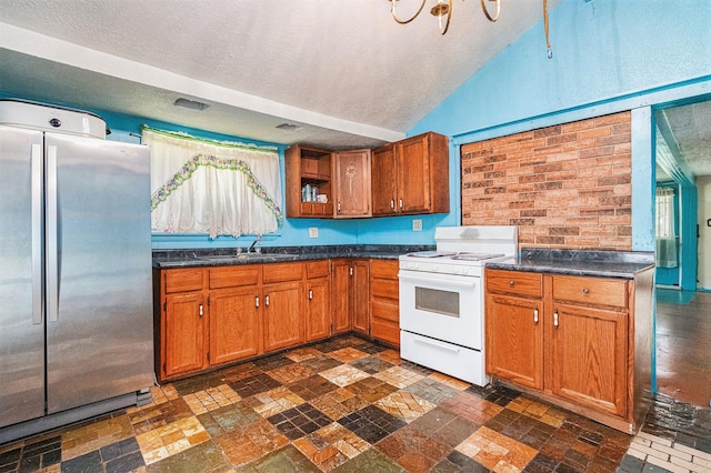 33891 Bertrand St, Niles, MI 49120 - kitchen with freestanding refrigerator, white range with gas stovetop, a textured ceiling, dark countertops, and brown cabinets
