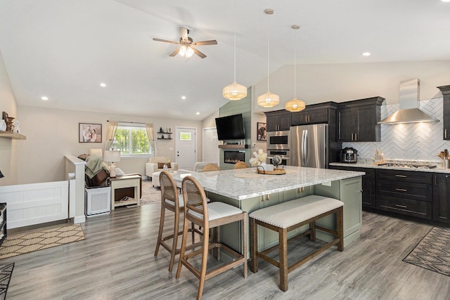 631 N Hilton Park Rd, Muskegon, MI 49442 - kitchen with extractor fan, appliances with stainless steel finishes, a breakfast bar, open floor plan, and vaulted ceiling