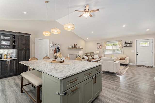 631 N Hilton Park Rd, Muskegon, MI 49442 - kitchen with a kitchen breakfast bar, light wood-type flooring, a center island, ceiling fan, and hanging light fixtures