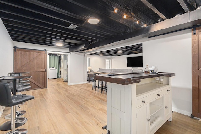 631 N Hilton Park Rd, Muskegon, MI 49442 - kitchen featuring a barn door, white cabinetry, baseboards, and light wood finished floors