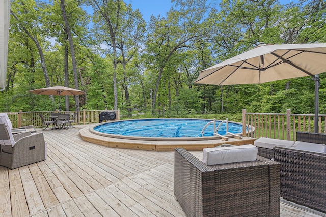 631 N Hilton Park Rd, Muskegon, MI 49442 - outdoor pool with a wooden deck, outdoor dining space, and view of scattered trees