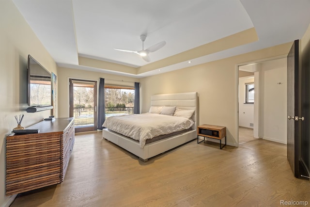 1000 Forest Ln, Bloomfield Hills, MI 48301 - bedroom with a tray ceiling, multiple windows, light wood-type flooring, and baseboards