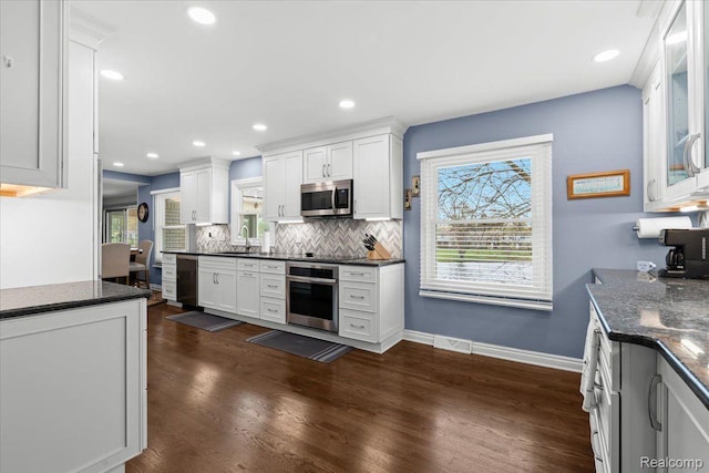 1425 Shankin Dr, Wolverine Lake, MI 48390 - kitchen featuring appliances with stainless steel finishes, a sink, decorative backsplash, dark wood-type flooring, and white cabinetry