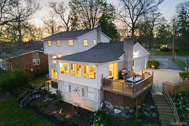 1425 Shankin Dr, Wolverine Lake, MI 48390 - back of property with stairway, a chimney, a garage, and a wooden deck