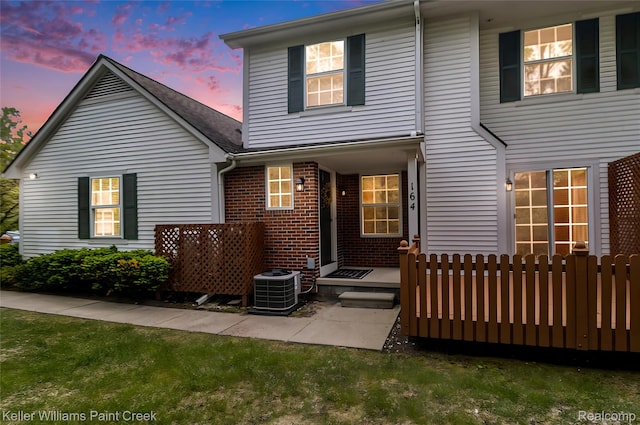 164 Barrington Cir, Lake Orion, MI 48360 - back of property at dusk featuring central air condition unit and brick siding