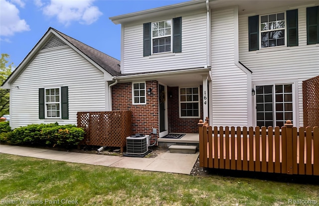 164 Barrington Cir, Lake Orion, MI 48360 - back of house featuring central AC unit and brick siding